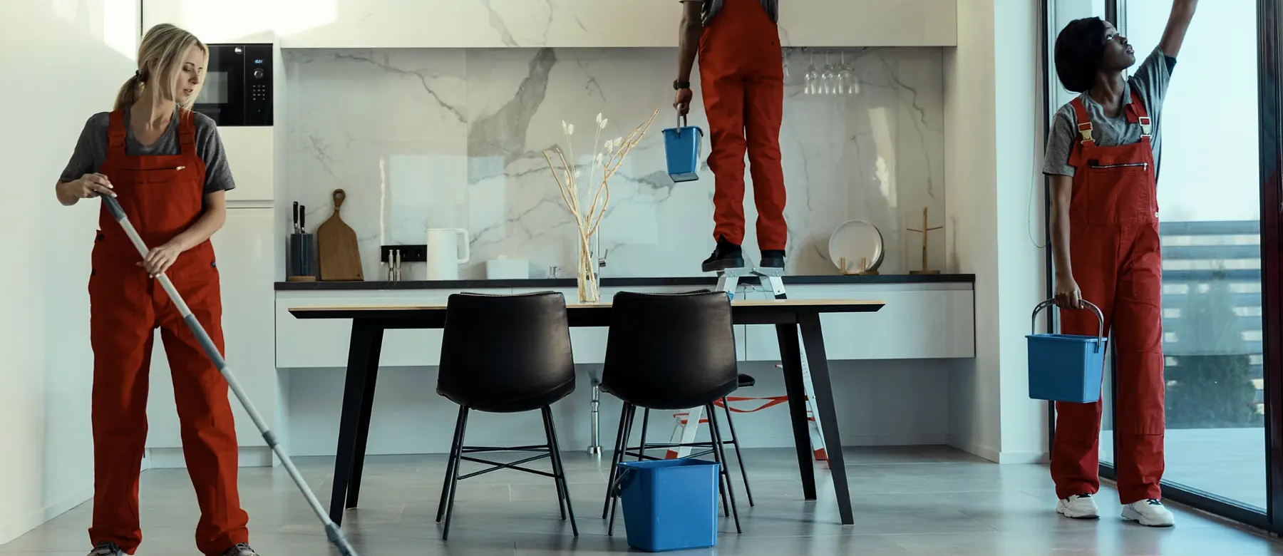 Cleaning crew in work overalls mopping floors and wiping windows in a bright space