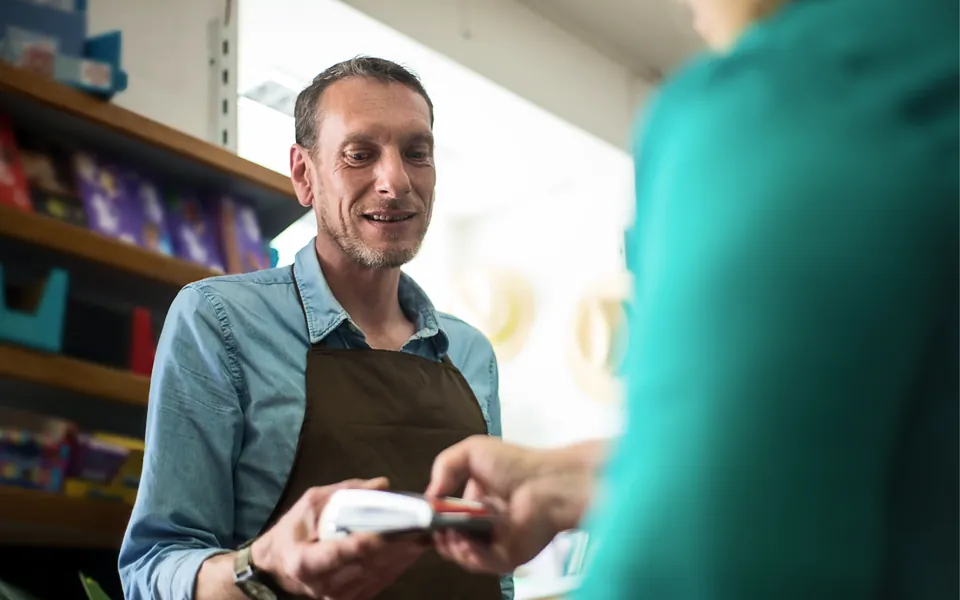 Store owner taking a card payment from a customer
