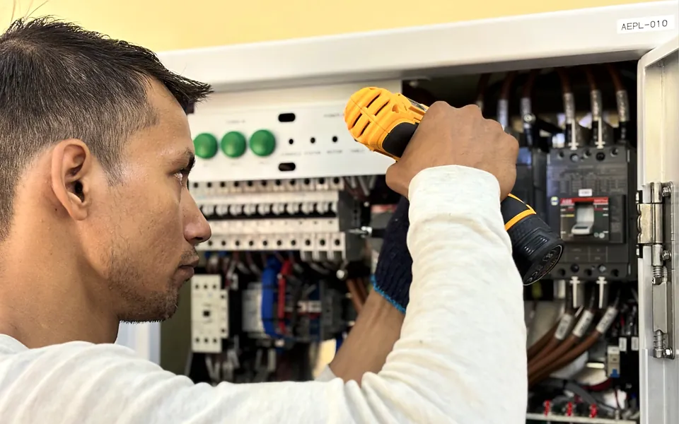 Electrician working inside a commercial electrical panel