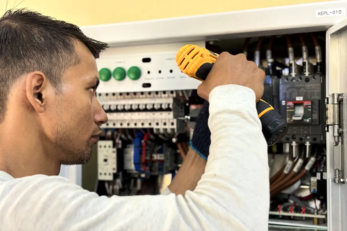 Electrician working inside a commercial electrical panel