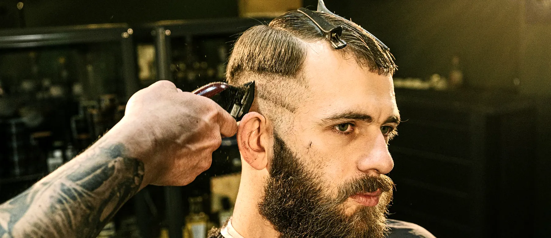 Barber trimming a client’s hair with clippers in a barbershop