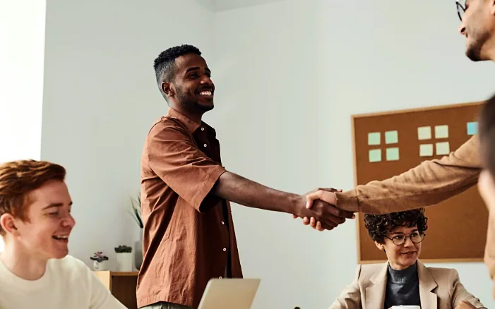 Startup founders shaking hands during a team meeting